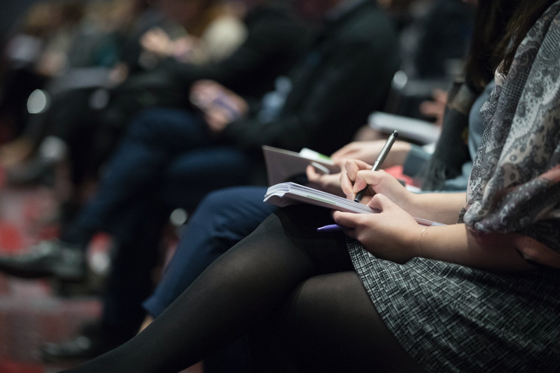 Professional Taking Notes at a Pharmaceutical Conference